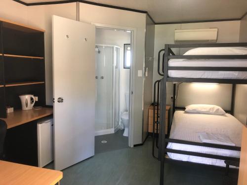 a room with two bunk beds and a bathroom at Peppermint Grove Beach Holiday Park in Capel