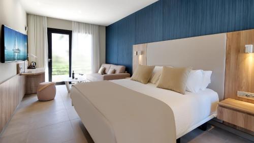 a bedroom with a large white bed and a blue wall at Club Maspalomas Suites & Spa - Adults Only in Maspalomas