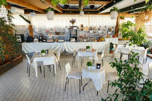 ein Restaurant mit weißen Tischen und Stühlen und einem Buffet in der Unterkunft Hotel Residence Confalone in Neapel