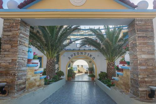 an entrance to a shopping mall with palm trees at Arhontiko Hotel in Foinikion