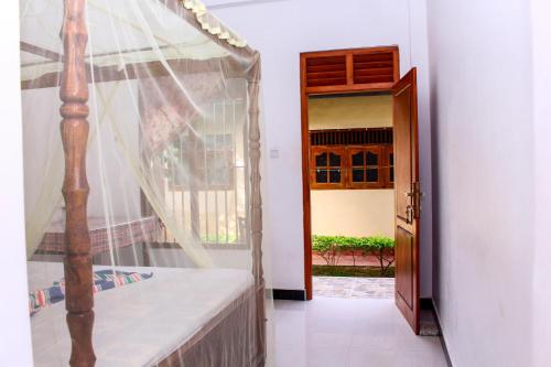 Habitación con cama, ventana y puerta en Lilac Garden Mirissa, en Weligama