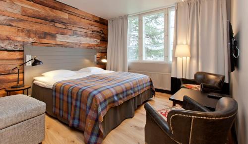 a hotel room with a bed and a chair at Holiday Club Kuusamon Tropiikki in Kuusamo