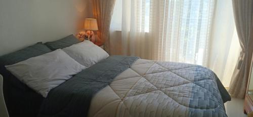 a bed sitting in a bedroom next to a window at Cityscape Residences Unit 510 in Bacolod