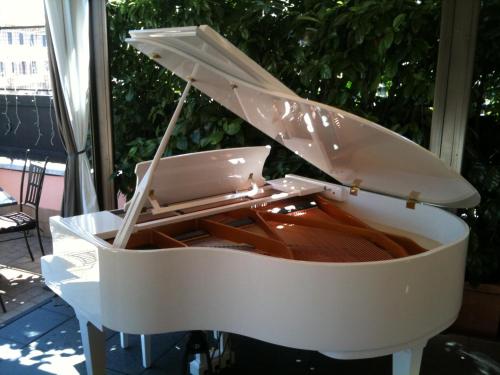 a white piano sitting on a porch at Hotel dei Consoli Vaticano in Rome