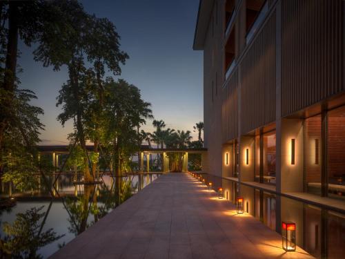 an external view of a building with lights on the walkway at Lohkah Hotel & Spa-Free Welcome Fruit Plate in Xiamen