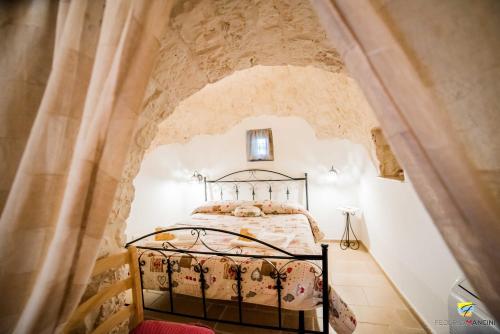 um quarto com uma cama numa parede de pedra em La linea dell'orizzonte em Alberobello