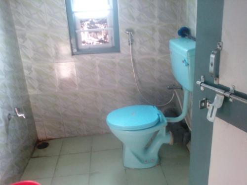 a bathroom with a blue toilet in a stall at Magnolia Homestay in Sombāri