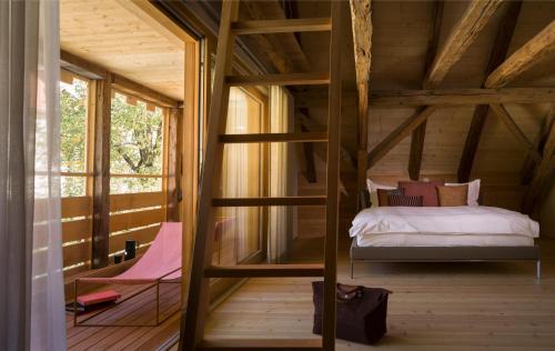 ein Schlafzimmer in einem Baumhaus mit einem Bett in der Unterkunft Casa Caminada in Fürstenaubruck