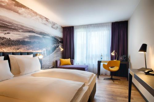 a hotel room with a bed and a desk at Welcome Hotel Neckarsulm in Neckarsulm