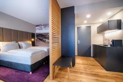 a hotel room with a bed and a kitchen at Welcome Hotel Neckarsulm in Neckarsulm