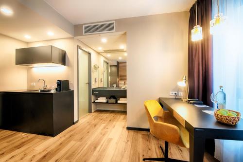 a kitchen with a desk and a sink in a room at Welcome Hotel Neckarsulm in Neckarsulm