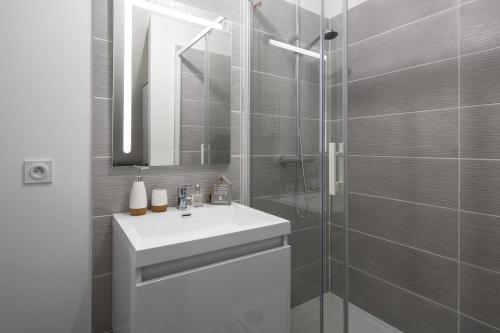 a bathroom with a sink and a glass shower at Azulejo by Cocoonr in Nantes