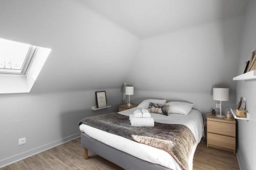 a white bedroom with a bed and a window at Azulejo by Cocoonr in Nantes