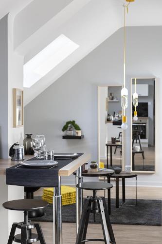 - une cuisine avec des tables et des chaises noires dans la chambre dans l'établissement Azulejo by Cocoonr, à Nantes