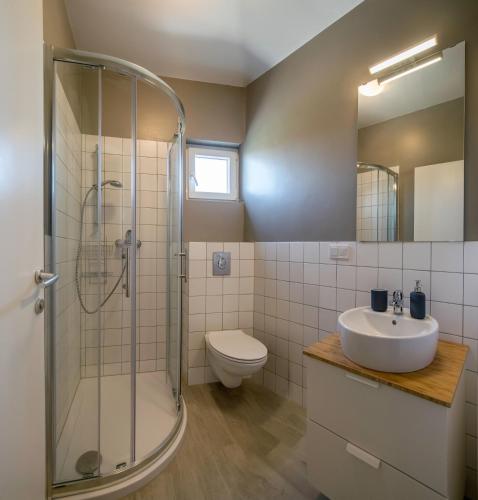 a bathroom with a shower and a sink and a toilet at Villa Gambera in Pirovac