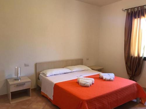 una camera da letto con un letto e due asciugamani di Residence Arruli a San Teodoro