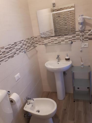 a bathroom with a sink and a toilet and a mirror at Le camere di Sabrina con bagno in camera in Sarzana
