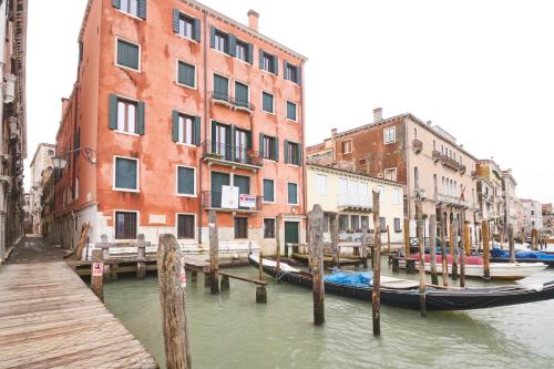 a boat docked at a dock in a canal with buildings at Charming Apartment On Grand Canal in Venice