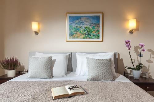 a bed with a book and pair of glasses on it at Minavra Hotel in Athens