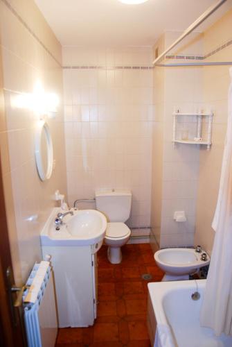 a bathroom with a sink and a toilet and a tub at Apartamentos Sanxenxo in Sanxenxo