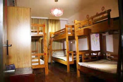 a room with three bunk beds and a door at Xi'an The Facebook Youth Hostel in Xi'an