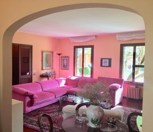 uma sala de estar com um sofá rosa e uma mesa em Opera Deluxe em Ravenna