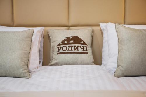 a bed with a pillow with a pokitt sign on it at Родичі in Zhashkiv