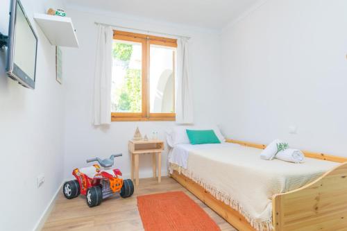 1 dormitorio con 1 cama y un coche de juguete en el suelo en Es Baladre, en Puerto de Alcudia