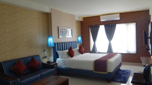 a hotel room with a bed and a couch at Arna Hotel in Devanahalli-Bangalore