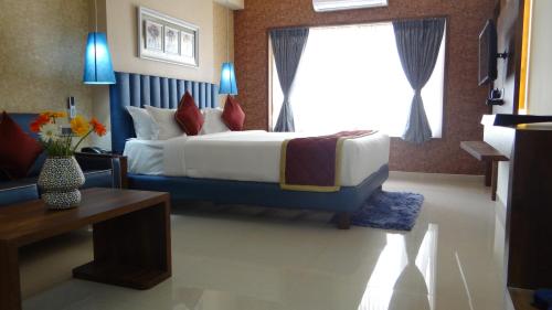 a bedroom with a large bed and a window at Arna Hotel in Devanahalli-Bangalore