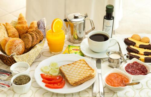 a table topped with plates of food and a cup of coffee at Minavra Hotel in Athens