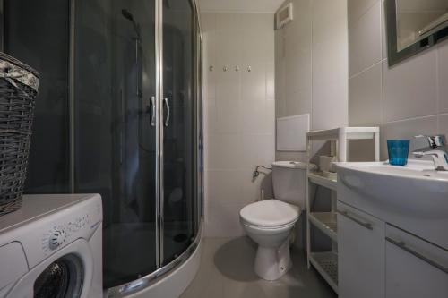a bathroom with a shower and a toilet and a sink at RentPlanet - Apartament Kościelna in Zakopane