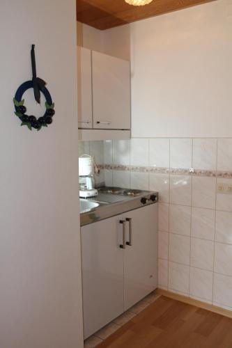 a small kitchen with white cabinets and a sink at Appartementhaus Moos in Lam