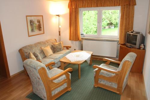 a living room with a couch and chairs and a tv at Appartementhaus Moos in Lam