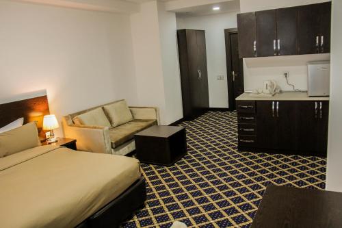 a hotel room with a bed and a chair and a sink at Kristal Hotel in Baku