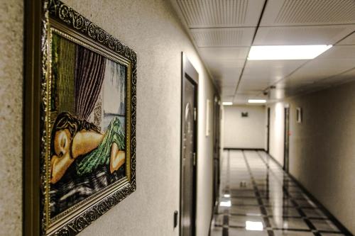 a painting hanging on a wall in a hallway at Kristal Hotel in Baku