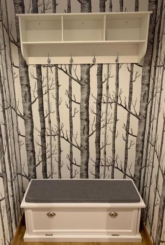 a bathroom with a white drawer with a forest wallpaper at Apartamentos Maladeta in Benasque