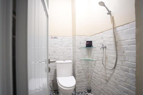 a bathroom with a shower with a toilet and a sink at RedDoorz near IPB Dramaga Bogor in Bogor