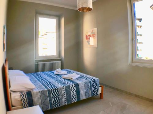 a bedroom with a bed with a blue and white blanket at Maraini Apartments by Quokka 360 - strategic location near Lugano station in Lugano