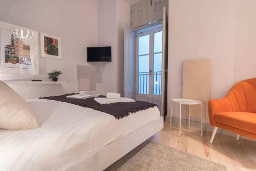 リスボンにあるLovelyStay - 3 Bedroom Downtown Wonderwallのベッドルーム(大型ベッド1台、椅子付)