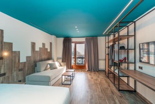 a room with a bed and a couch and a staircase at Ushuaia, The Mountain Hotel in Arinsal