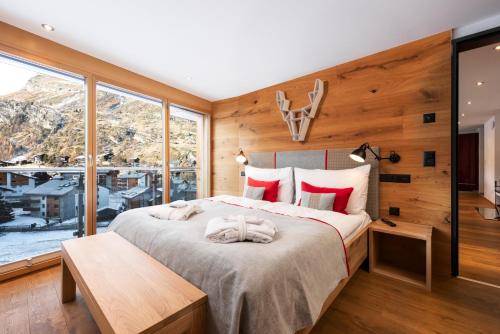a bedroom with a large bed and a large window at Chalet Nepomuk in Zermatt