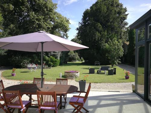 a table and chairs with an umbrella on a patio at H de Surgères in Surgères