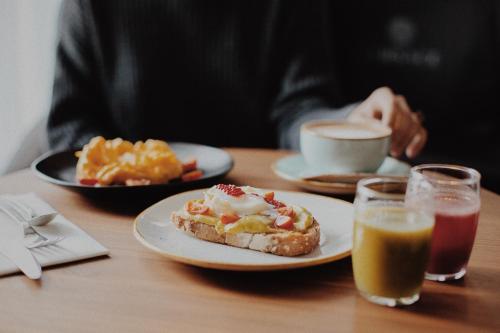 a person sitting at a table with plates of food and drinks at ICON Embassy in Madrid