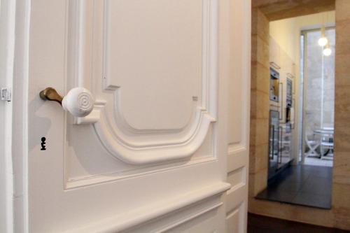 uma porta branca com uma maçaneta com um corredor em Bordeaux City Gardens em Bordeaux