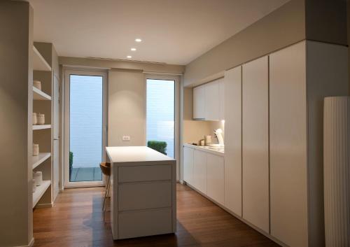une cuisine avec des placards blancs et une grande fenêtre dans l'établissement Studio K, à Courtrai