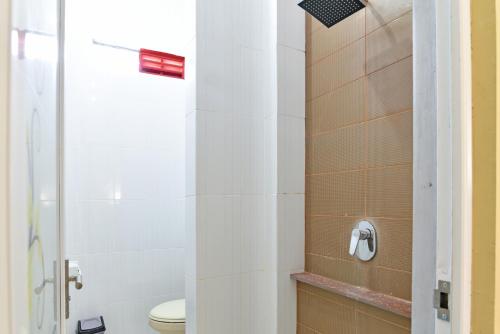 La salle de bains est pourvue d'une douche et de toilettes. dans l'établissement RedDoorz @ Uluwatu Bali, à Uluwatu