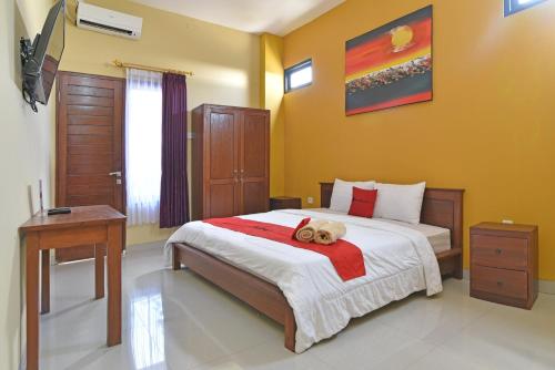 - une chambre avec un lit doté d'un ours en peluche dans l'établissement RedDoorz @ Uluwatu Bali, à Uluwatu