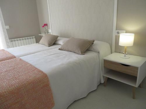 a bedroom with two beds and a table with a lamp at Alcañiz Flats I in Alcañiz