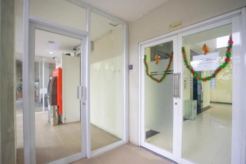 a hallway with glass doors and christmas decorations at RedDoorz Apartment at Bogor Valley in Bogor